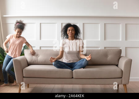 Calm black mom meditate distracted from outer noise Stock Photo