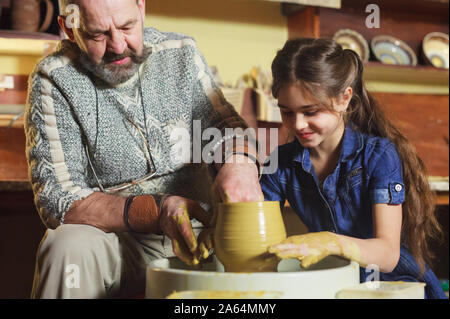 the master with the child molds a clay jug Stock Photo