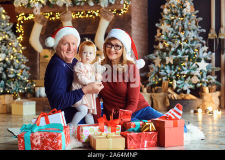 Grandparents and little girl in the house at Christmas. Stock Photo
