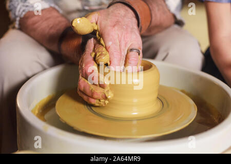 the master with the child molds a clay jug Stock Photo