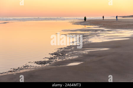People enjoying a beautiful winter sunset on the beach at Jacksonville Beach in Northeast Florida. (USA) Stock Photo