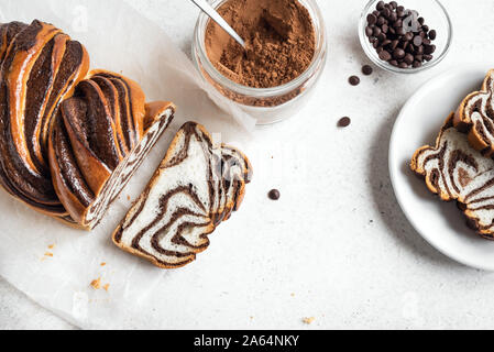 Chocolate Babka or Brioche Bread. Homemade sweet desert pastry - chocolate swirl bread, sliced on white background. Stock Photo