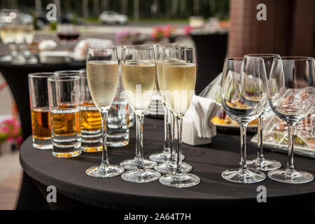 A buffet table on the terrace with glasses of champagne. Glasses with champagne and empty wine glasses are on the terrace table. Stock Photo