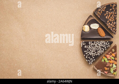 Pieces of chocolate on vintage parchment. Brown craft paper. Art design. Dark spiced chocolates. Sweet dessert. Food background. Neutral mockup, layou Stock Photo