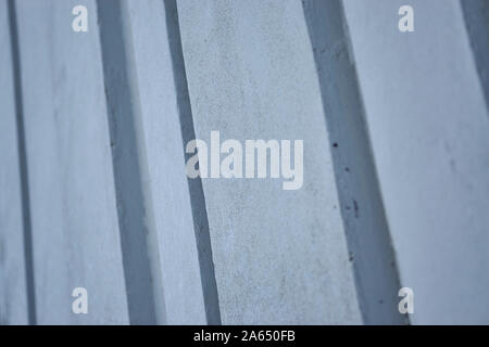 Background image made up of a close up of a modern ribbed concrete wall with repeating vertical patterns and a flat concrete texture Stock Photo