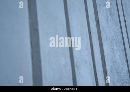 Background image made up of a close up of a modern ribbed concrete wall with repeating vertical patterns and a flat concrete texture Stock Photo