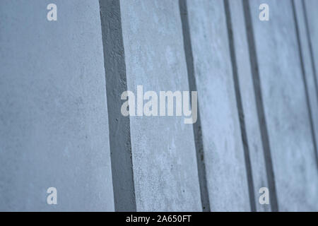 Background image made up of a close up of a modern ribbed concrete wall with repeating vertical patterns and a flat concrete texture Stock Photo