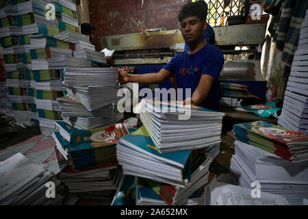 Dhaka, Bangladesh - October 22, 2019. Bangladeshi book binding worker working in a printing house at bangla bazar in Dhaka, Bangladesh. Stock Photo