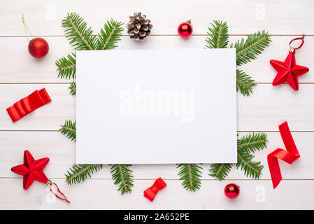 Empty paper for greeting text or logo surrounded with Christmas fir branches and decorations. Stock Photo