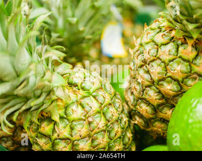 ripe pineapples on the counter. Pineapple collection in a shop window. close-up. New Year fruit concept, freshly squeezed vitamin juice Stock Photo