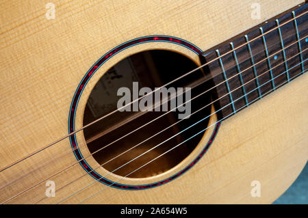 From a series of closeups of acoustic guitar sound hole and steel strings, with alternate strings vibrating after being picked. Stock Photo