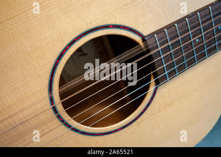 From a series of closeups of acoustic guitar sound hole and steel strings, with alternate strings vibrating after being picked. Stock Photo