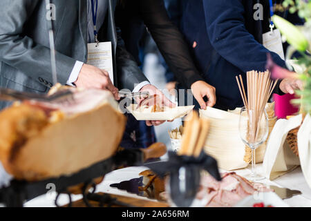 Businesspeople at banquet lunch break at business conference meeting. Assortment of food and drinks. Stock Photo