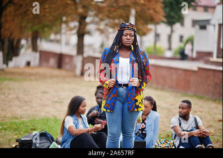 Group of five african college students spending time together on campus at university yard. Black afro friends studying. Education theme. Stock Photo