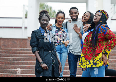 Group of five african college students spending time together on campus at university yard. Black afro friends studying. Education theme. Stock Photo