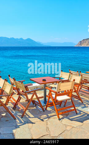 Cafe at waterfront by the sea with tables outdoor and panoramic view, Greece Stock Photo