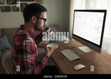 Young handsome designer working on project on computer Stock Photo