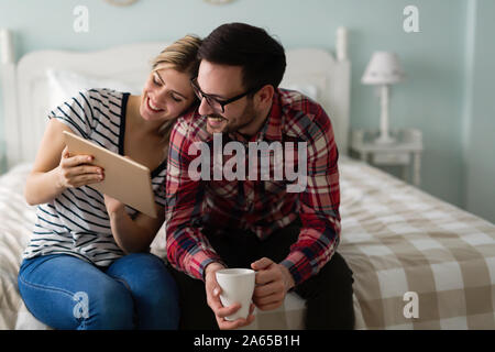 Young attractive couple using tablet in bedroom Stock Photo