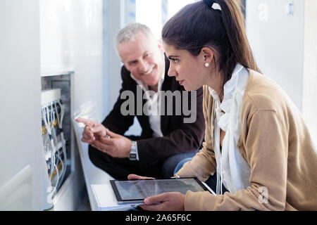 Architect Showing Heating System To Assistant In Construction Site Stock Photo