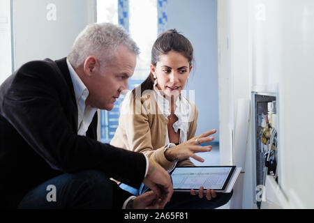 Architect Showing Heating System To Assistant In Construction Site Stock Photo