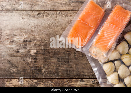 Salmon packaged in plastic on wooden table. Top view Stock Photo