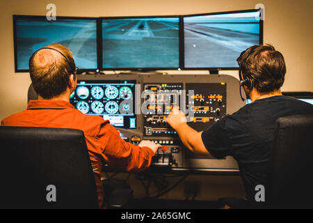 Two student pilots operating a flight simulator Stock Photo
