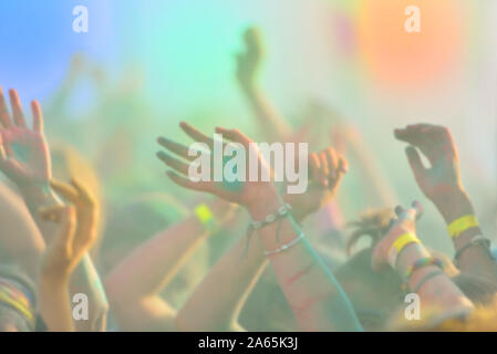 Defocused image of close-up with pople hands on running marathon, people covered with colored powder. Stock Photo