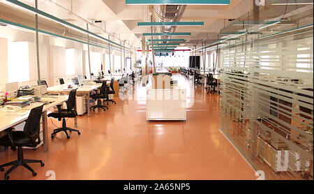 Photo of a large corporate office with desks chairs computers and the equipment needed by employees Stock Photo