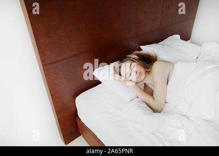 sun shinning portrait of american girl sleeps in white bed Stock Photo