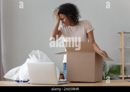 Frustrated black girl disappointed with purchased product Stock Photo