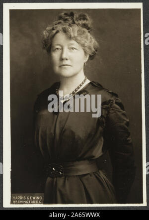 Ada S. Flatman by Harris & Ewing in a 3.5 x 5 in photographic print. A cropped version of this photograph was published in The Suffragist 5, no. 58 (Mar. 3, 1917): 10. The caption on an enlarged, cropped version of the identical image in the same folder reads: Miss S. Ada Flatman, of London, England, is Advertising and Business Manager of 'The Suffragist,' official weekly organ of the Congressional Union for Woman Suffrage and the National Woman's Party.    Formal portrait, half-length, standing with arms pulled behind back, wearing dark, belted dress with stain trim, small bow at v-neck, and Stock Photo