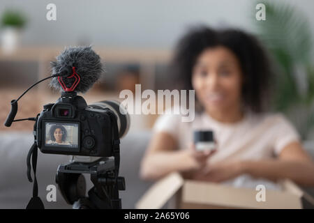 Professional camera shooting black female unpacking vlog Stock Photo