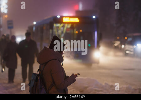 Checking the smartphone while waiting for the bus to come Stock Photo