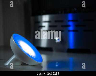 Smart home lamp light with coloured LED on fireplace - Dark Blue Stock Photo