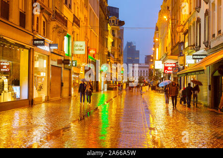 BRUSSELS, BELGIUM - OCTOBER 06, 2019: People walking by Old Town shopping street of Brussels in the rain at twilight Stock Photo