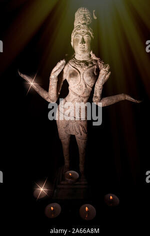 Goddess Lakshmi. Diwali festival of lights. Traditional Hindu statue by candlelight. Religious celebration of Deepavali with burning tealight candles Stock Photo