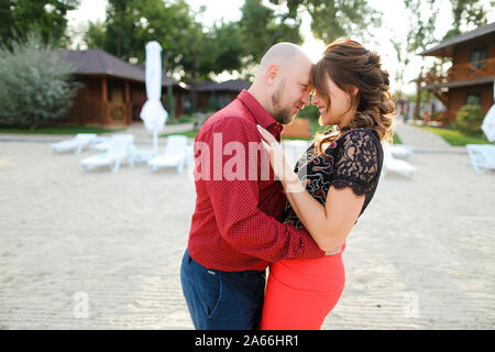 Bald caucasian husband wearing red shirt and dancing with wife on backyard. Stock Photo