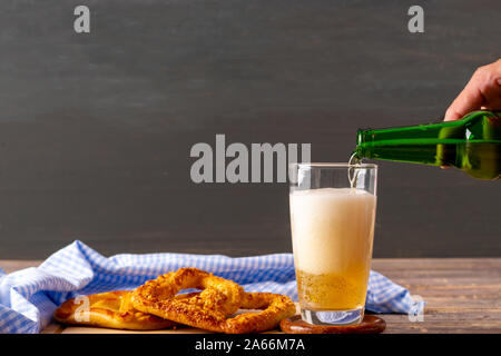 Oktoberfest concept. Woman hand pouring beer  on wooden table. Stock Photo