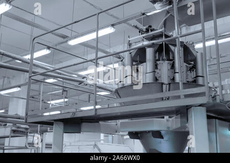 fragment of an industrial machine for the automatic packing of candies in the shop of a confectionery factory Stock Photo