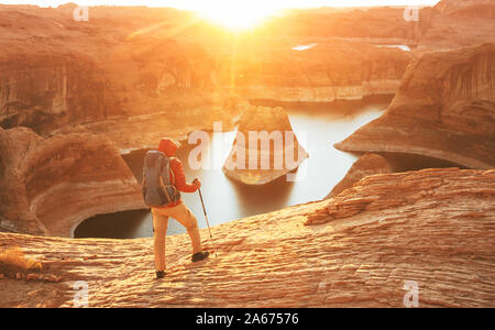 Unusual natural background. Reflection Canyon on Lake Powell, Utah, USA. Inspiring hiking scene-man resting on the beautiful sunset point. Stock Photo