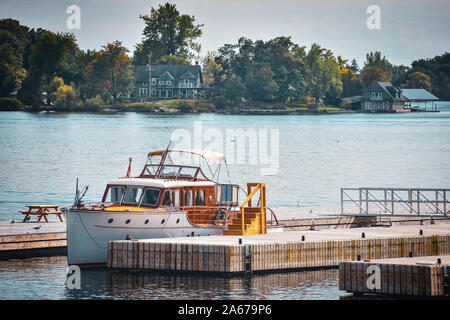 Classic yacht in the dock. Lake Ontario in autumn. Colorful vivid trees. Canada, United States of America. Stock Photo