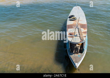 Small traditional wooden boat moored in the clear waters of the Tapajos River in sunny summer day near the Amazon River in Santarem, Para, Brazil. Stock Photo