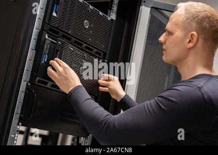 IT Consultant Installing Servers In Large Cloud Datacenter Stock Photo