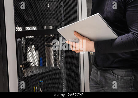 Midsection of IT Support Using Digital Tablet in Large Datacenter Stock Photo