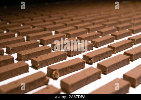 fillings for sweets before pouring with liquid chocolate move on the conveyor of a confectionery factory Stock Photo