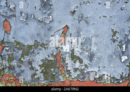 Peeling gray paint on the wall background. Texture of an old wall of gray and brown color. Stock Photo