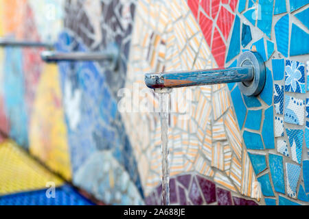 Water source taps in the street from the wall. Public drinking water taps in the street. Stock Photo