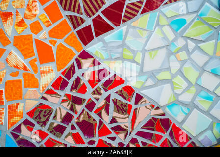 Pattern of a mosaic on a wall. Bright, decorative and colorful tiles, splinters and crocks. Stock Photo