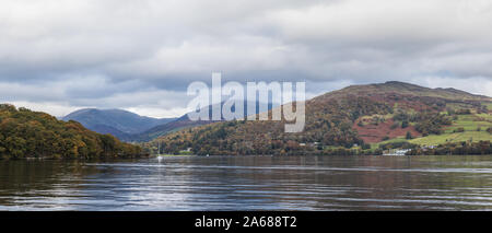 A multi image panorama looking across Lake Windermere showing the natural colours of the surrounding trees and hills seen in the autumn of 2019. Stock Photo