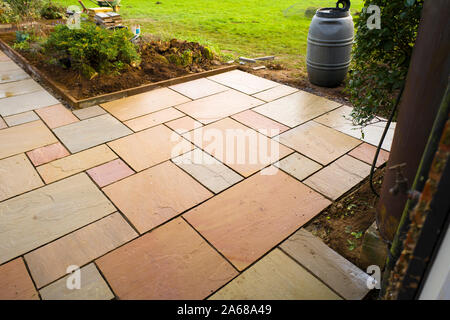 Newly laid mineral slabs setting out a path and seating area in an English garden Stock Photo